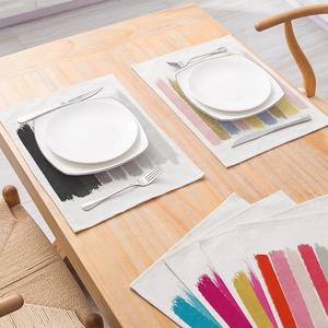Artistic striped cotton linen placemat with colorful strokes on a wooden dining table