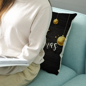 Christmas polyester pillowcase with black wood texture and gold ornaments on a blue sofa