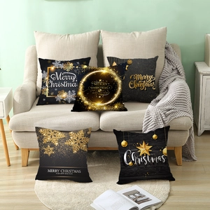 Cinq housses de coussin de Noël noir et or avec flocons sur un canapé moderne