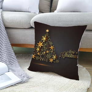 Housse de coussin Noël noir et or avec sapin en flocons dorés sur canapé gris