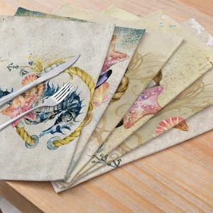 Marine themed cotton linen placemats with vintage starfish and anchor prints on wooden table