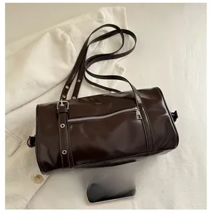 Deep brown cylindrical pillow bag shown with a phone for precise size comparison