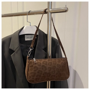 Detail of leopard print shoulder bag with matte texture and durable zipper closure