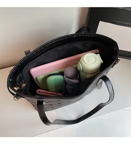 Detail view of large capacity tote bag interior with tablet, bottle, and umbrella
