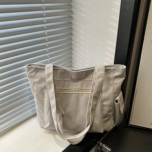 Large beige corduroy tote bag with front zipper pocket and side flap for daily commute