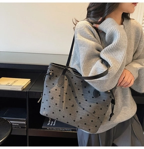 Close-up of grey wool tote bag featuring black polka dots and small bow embroidery