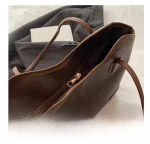 Close-up of litchi grain leather tote bag with gold zipper and stylish contrast handle