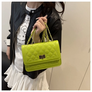 Detailed view of neon green quilted crossbody bag with metal chain and classic turn-lock