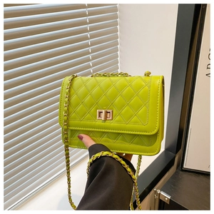 Detailed shot of lime green quilted shoulder bag featuring gold clasp and chain strap
