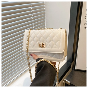 Detail of white quilted handbag with gold turn-lock and leather-woven chain strap