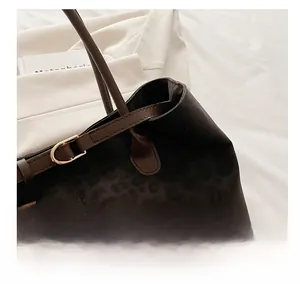 Detailed macro view of leopard print suede tote with leather strap and gold D-ring hardware