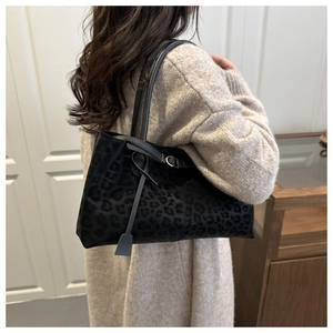Detail view of large faux suede tote bag with subtle black leopard print and slim straps