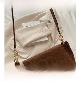 Close-up of leopard print shoulder bag with gold chain link and flap closure detail