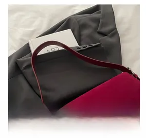 Macro view of magenta matte suede shoulder bag with fine leather strap detail