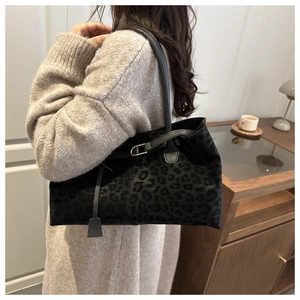 Detail view of large leopard print faux suede tote bag with slim black leather shoulder strap