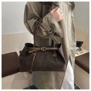 Detail of leopard print suede tote bag with stylish buckle strap and texture