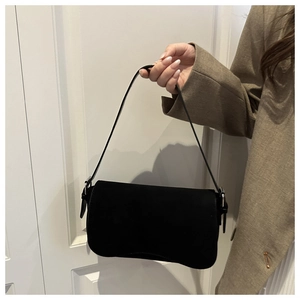 Detail of minimalist black matte shoulder bag with a silver metal buckle and flap closure