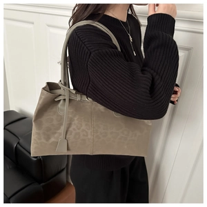 Detail of leopard print tote bag in taupe suede, shown on shoulder over black knitwear