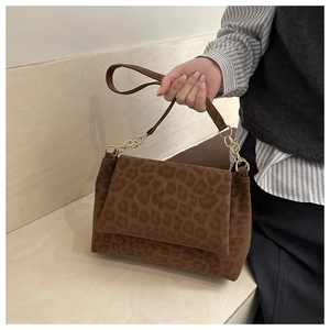 Detail of leopard print shoulder bag with gold chain strap and matte texture