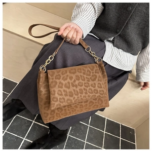 Detail of leopard print handbag showing matte texture and gold chain strap detail