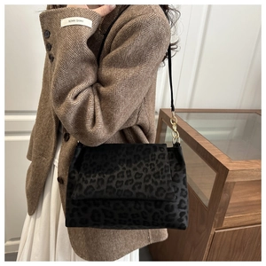 Detail of grey leopard print crossbody bag featuring soft matte texture and gold hardware