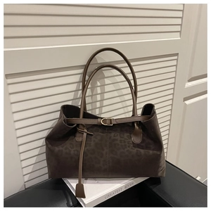 Detail of leopard print faux suede tote bag featuring leather buckle and long handles