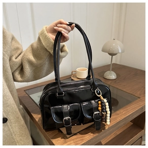 Detail der glänzenden schwarzen Boston Bag mit Vordertaschen und Perlenanhänger