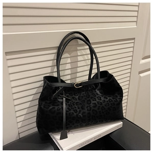 Detailed view of leopard print suede tote bag with leather strap and decorative pendant