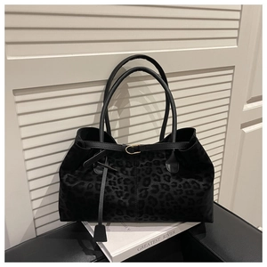 Detail of black leopard print suede tote bag with fine texture and golden metal buckle