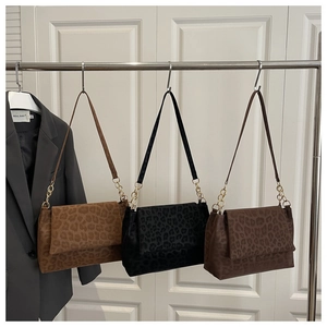 Three leopard print suede shoulder bags in brown and black with gold chain straps