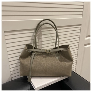 Close-up of leopard print tote bag with grey-green suede texture and gold buckle detail