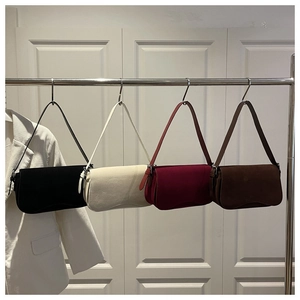 Detail view of four minimalist suede underarm bags in black, beige, wine red, and brown