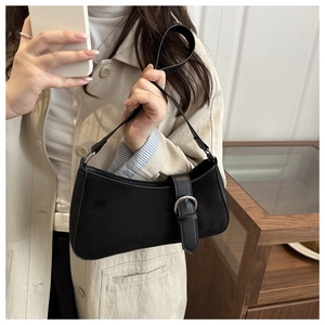 Détail d'un sac porté épaule demi-lune en daim noir avec boucle argentée élégante