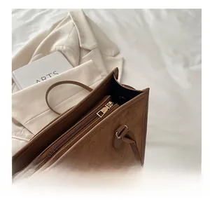Detail of premium brown embossed suede bag with high-quality golden metal zipper closure