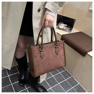Close-up of brown clover embossed faux suede tote bag with smooth leather trim