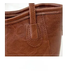 Detail shot of vintage brown tote bag showing premium PU leather texture and neat stitching