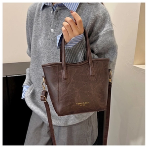 Detail of dark brown vintage bucket bag with adjustable straps and golden metal hooks