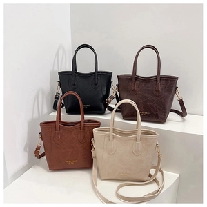 Detail showing high-quality leather texture and gold embossed logo on four color bucket bags