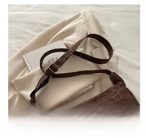 Detail showing the adjustable leopard print shoulder strap and metal buckle of the tote bag