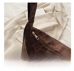 Close-up of leopard print tote bag featuring a smooth gold zipper and satin finish