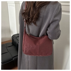 Detail of burgundy leopard print shoulder bag with sleek metallic zipper and silky texture