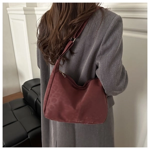 Detailed view of burgundy leopard print hobo bag worn with a grey wool blazer