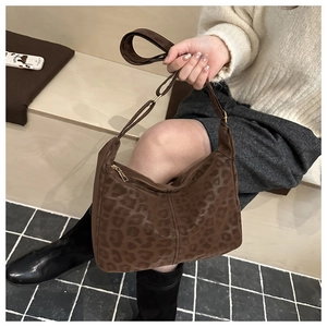 Detail of a leopard print hobo bag showing the texture and wide adjustable shoulder strap