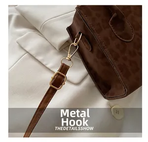 Detail of leopard print bag featuring premium matte fabric and gold metal hook hardware