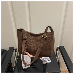 Close-up of brown leopard print tote bag with soft texture and golden metal buckle detail