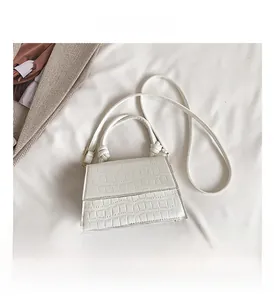 Détail du sac blanc en cuir embossé crocodile avec poignée nouée et boucles dorées