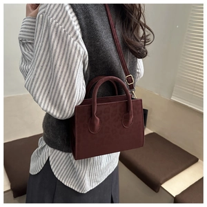 Detail of burgundy leopard print crossbody bag showing suede texture and metal buckle
