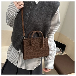 Detail of leopard print crossbody bag with suede texture and adjustable shoulder strap