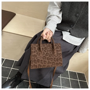 Detail shot of leopard print handbag with plush texture and stylish crossbody straps