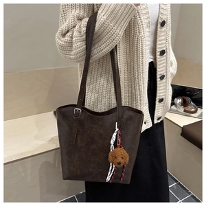Dettaglio borsa tote marrone scuro in ecopelle con ciondolo a forma di orso e fibbia silver